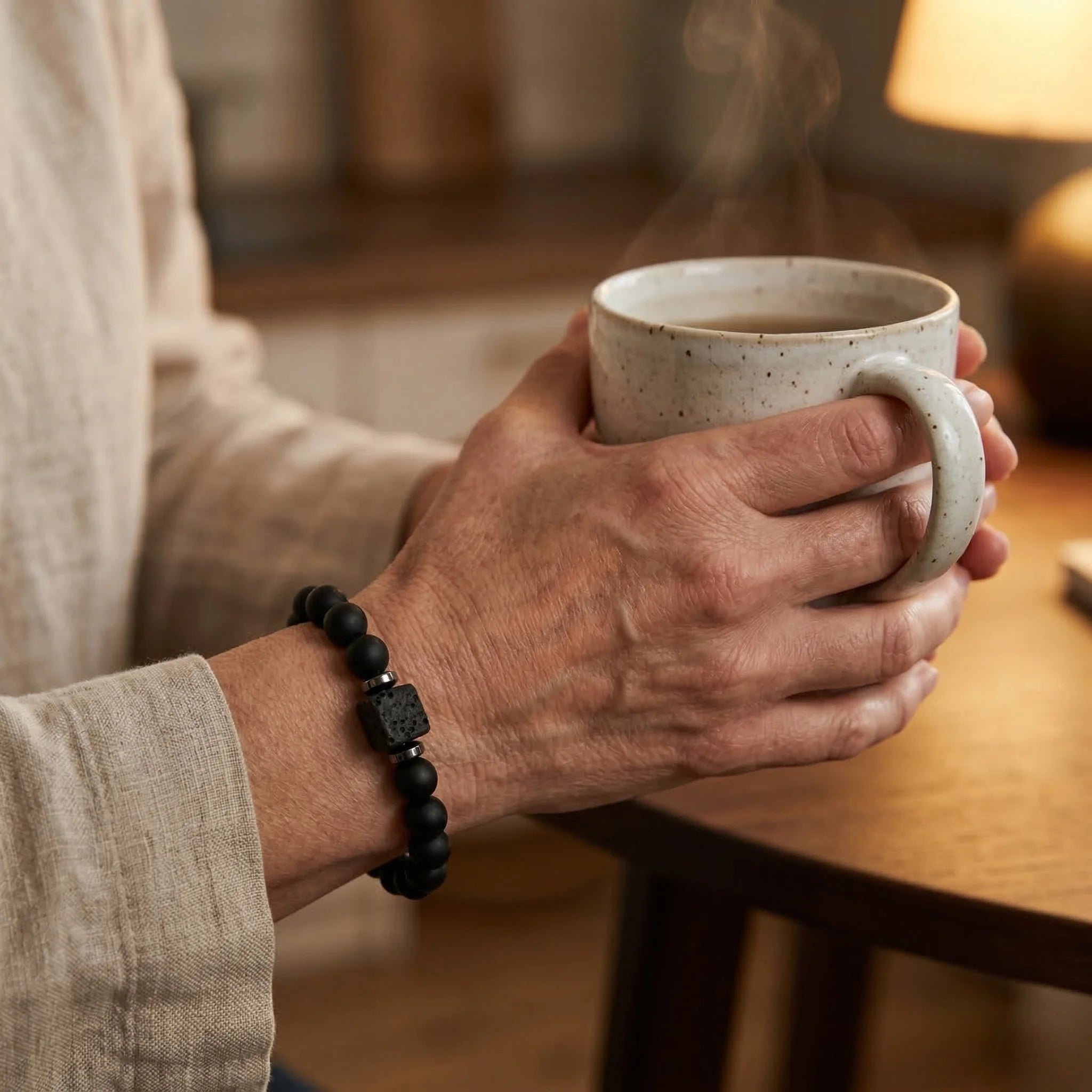 Person holding a steaming mug with a blurred indoor background