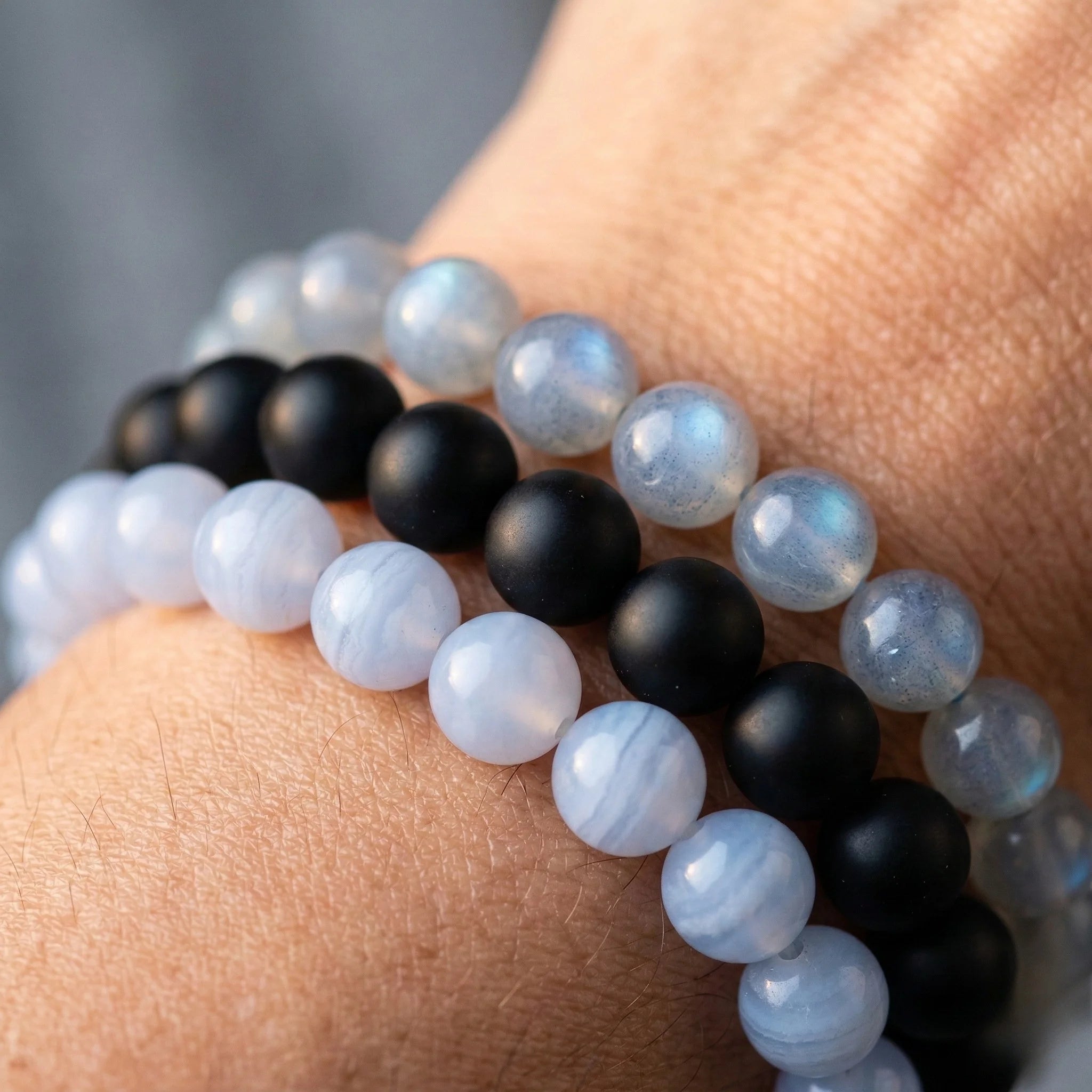Close-up of a wrist wearing two beaded bracelets with black and white beads.