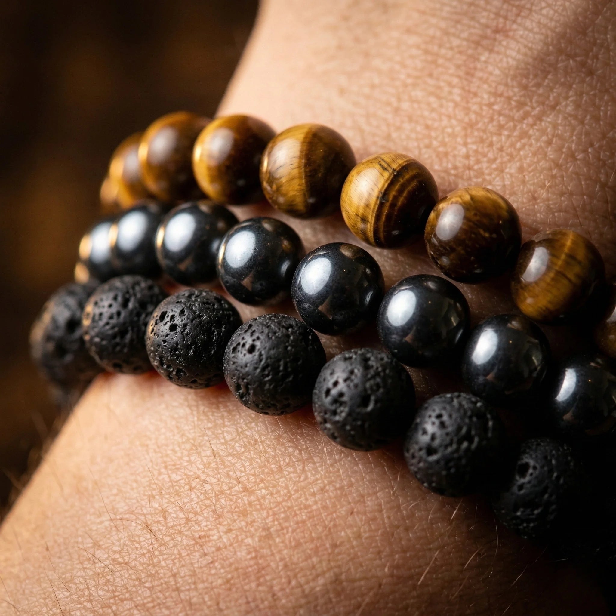 Close-up of a wrist wearing two bracelets with black and brown beads.