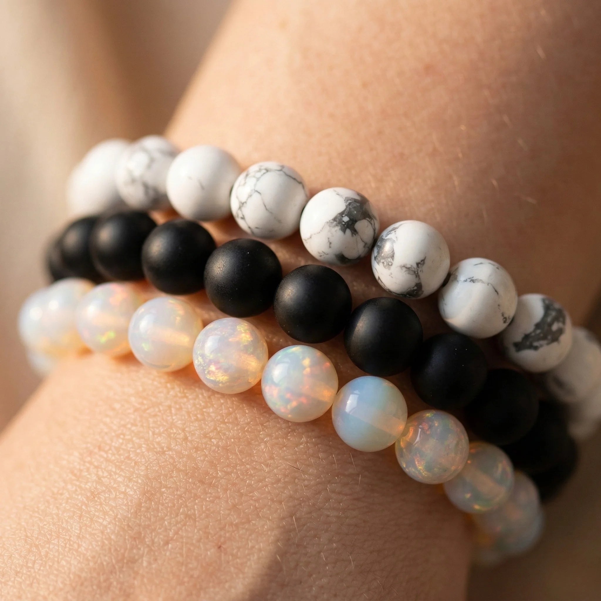 Stack of beaded bracelets on a wrist with a neutral background