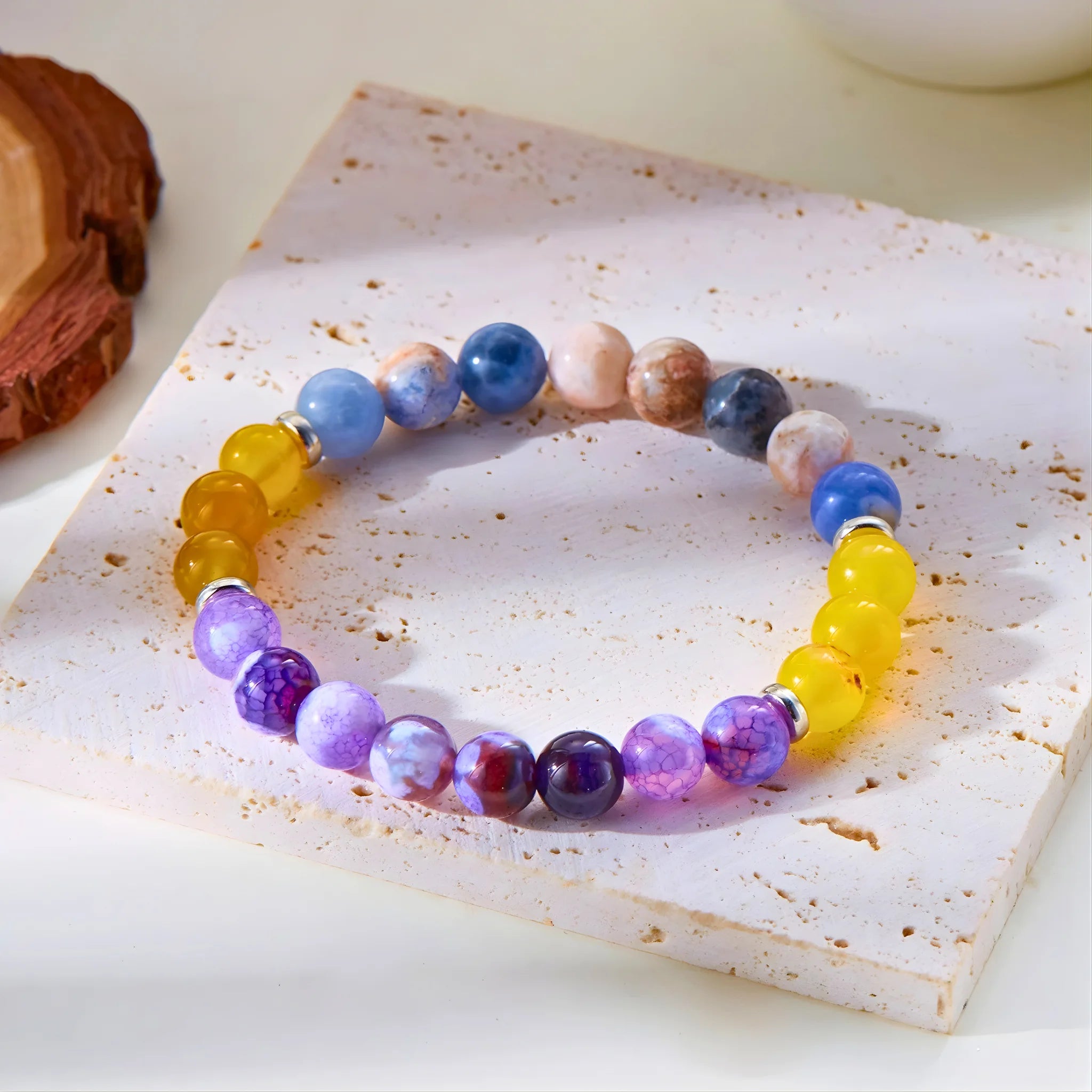 Success gemstone bracelet placed on stone slab.