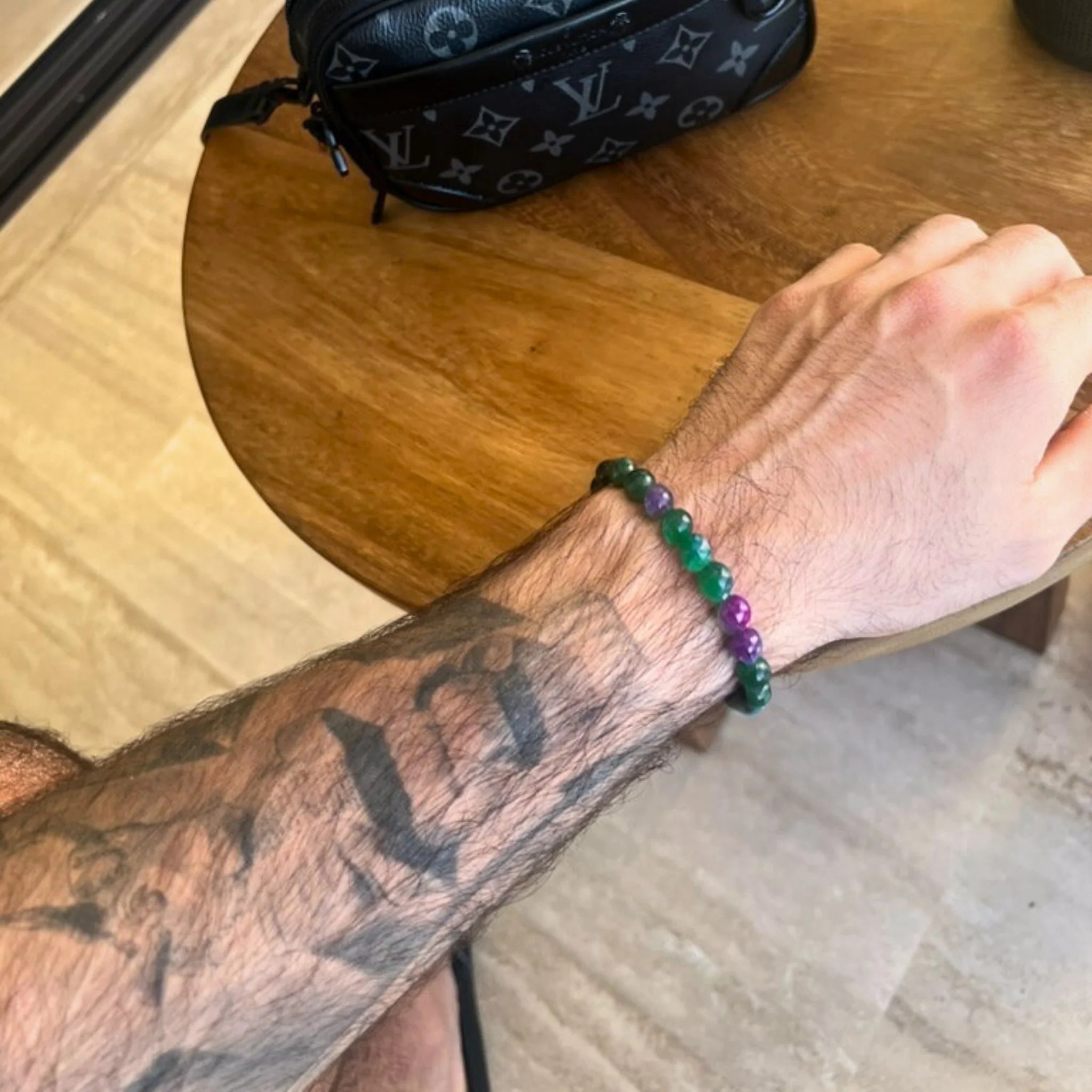 Gemstone4K fluorite bracelet worn on wrist outdoors, showing translucent lavender and green tones.