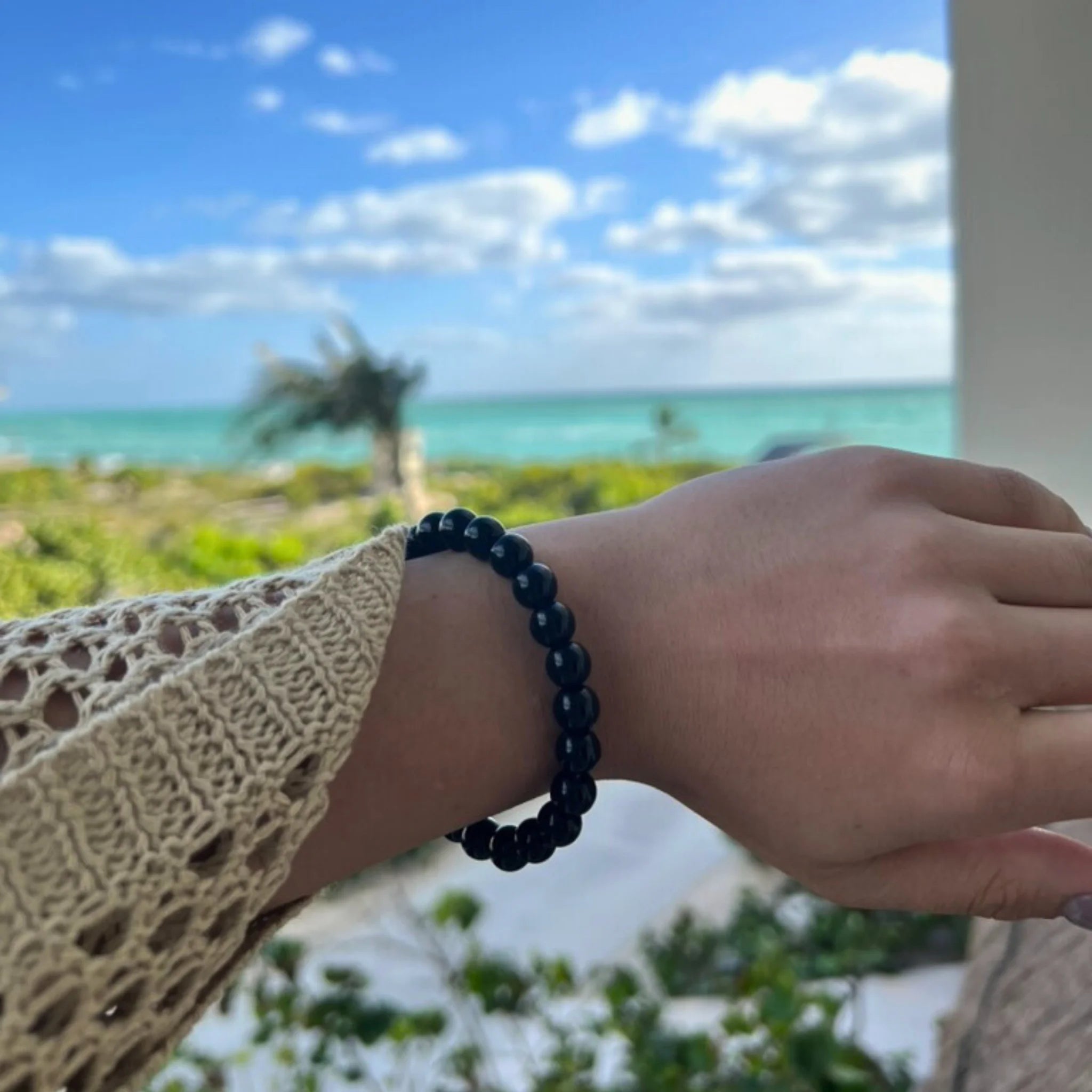 Gemstone4K onyx bracelet worn on wrist, showing deep black polished stones with a sleek appearance.