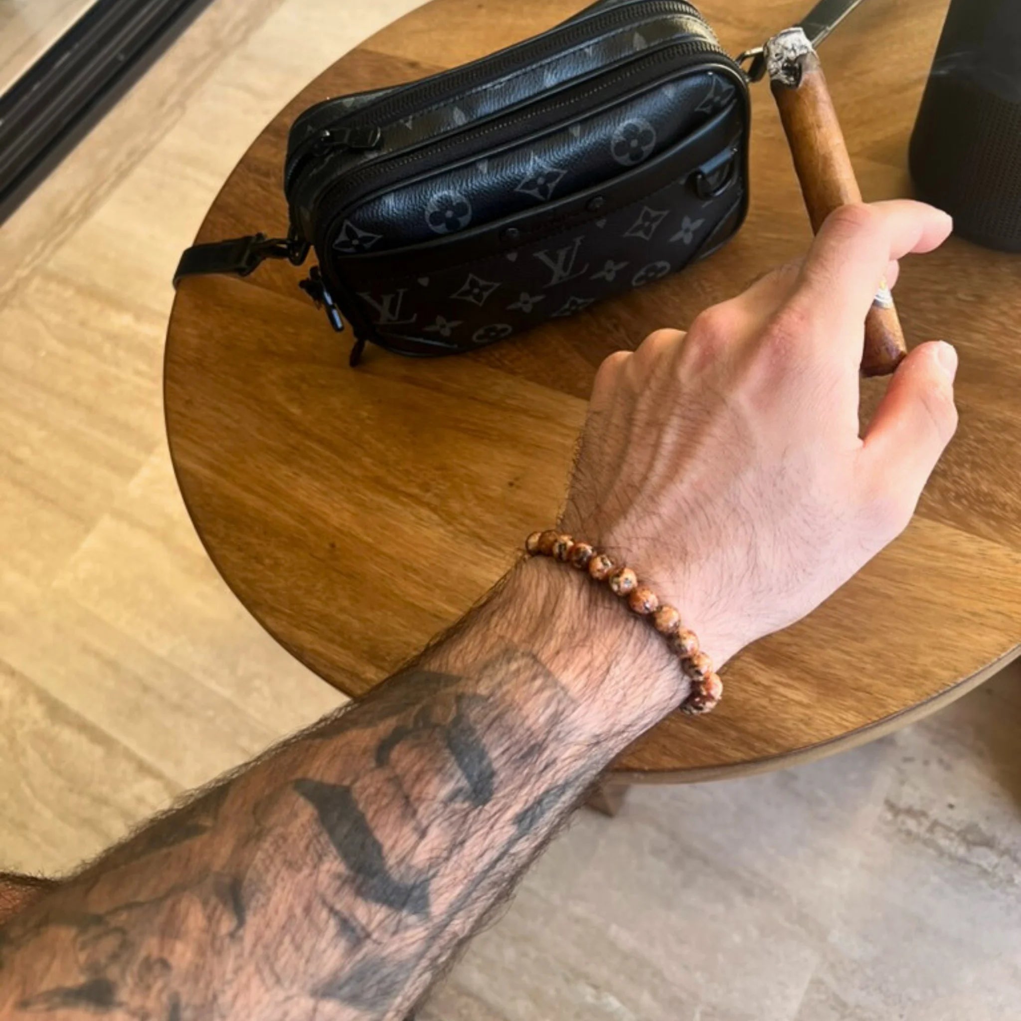 Gemstone4K red leopard skin jasper bracelet worn on wrist outdoors, showing natural patterns and warm red tone.