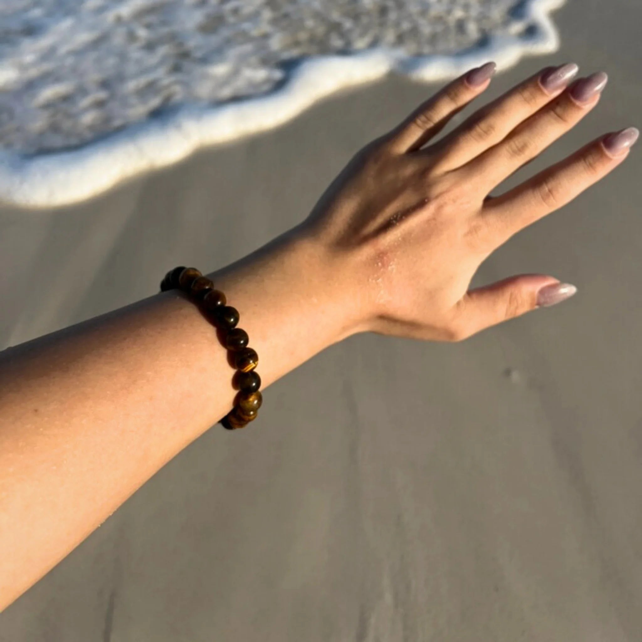 Gemstone4K tiger’s eye bracelet worn on wrist, showing golden brown tones and natural shine.