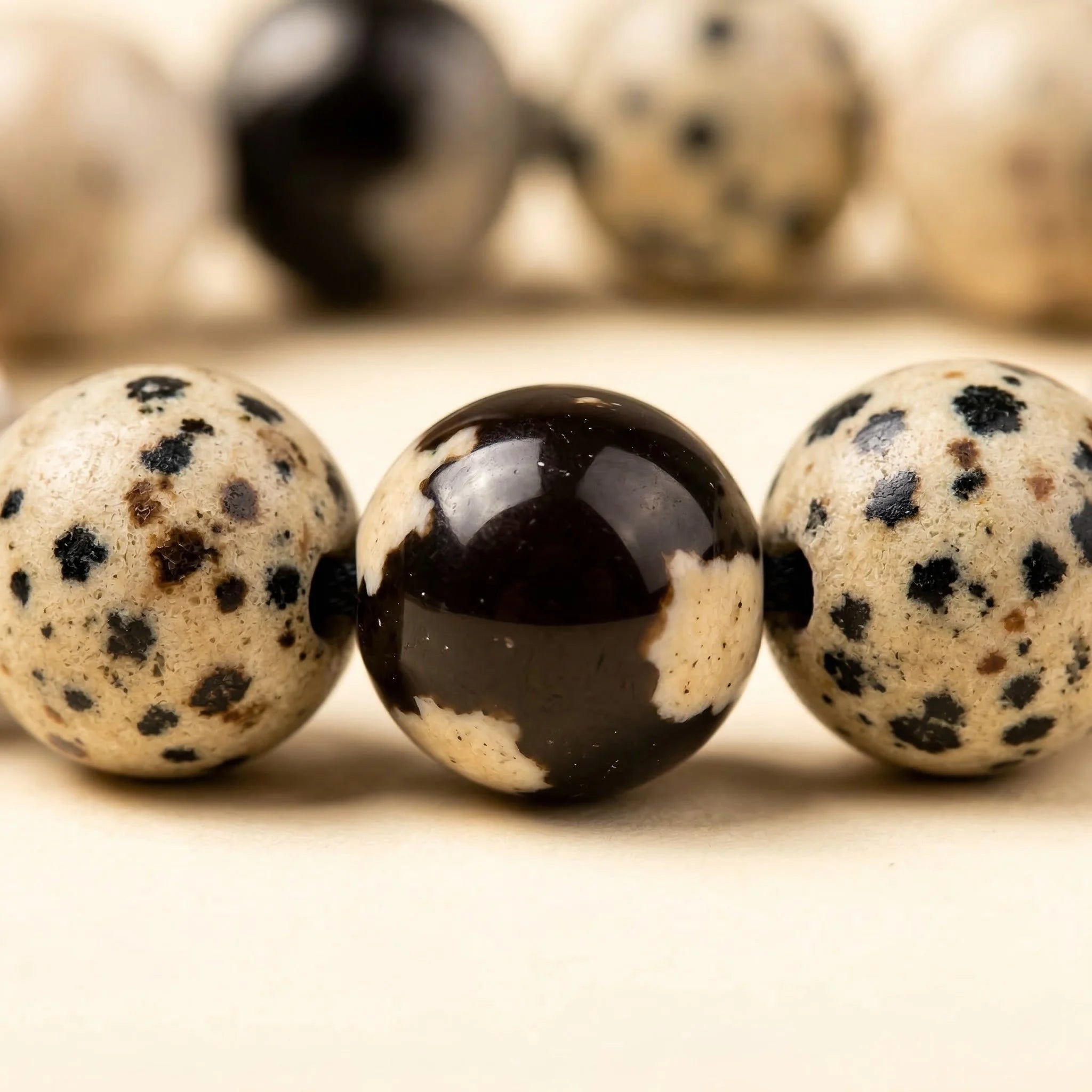 Close-up of three speckled marbles on a light surface with blurred background