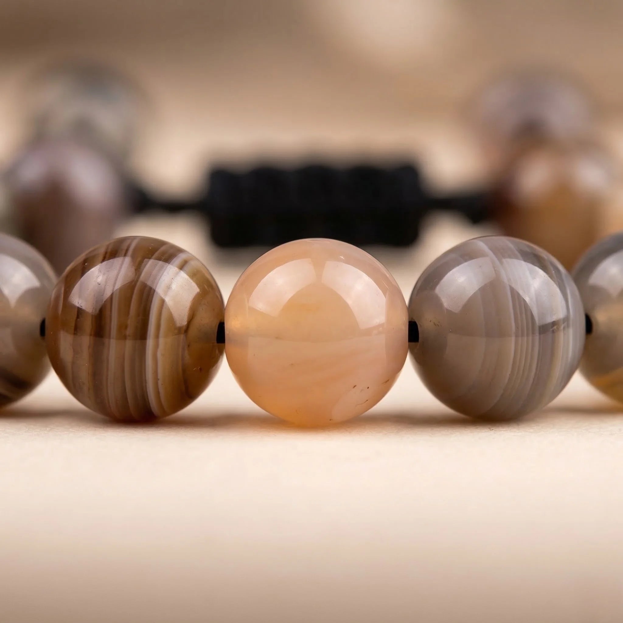 Close-up of a necklace with brown and beige beads on a blurred background