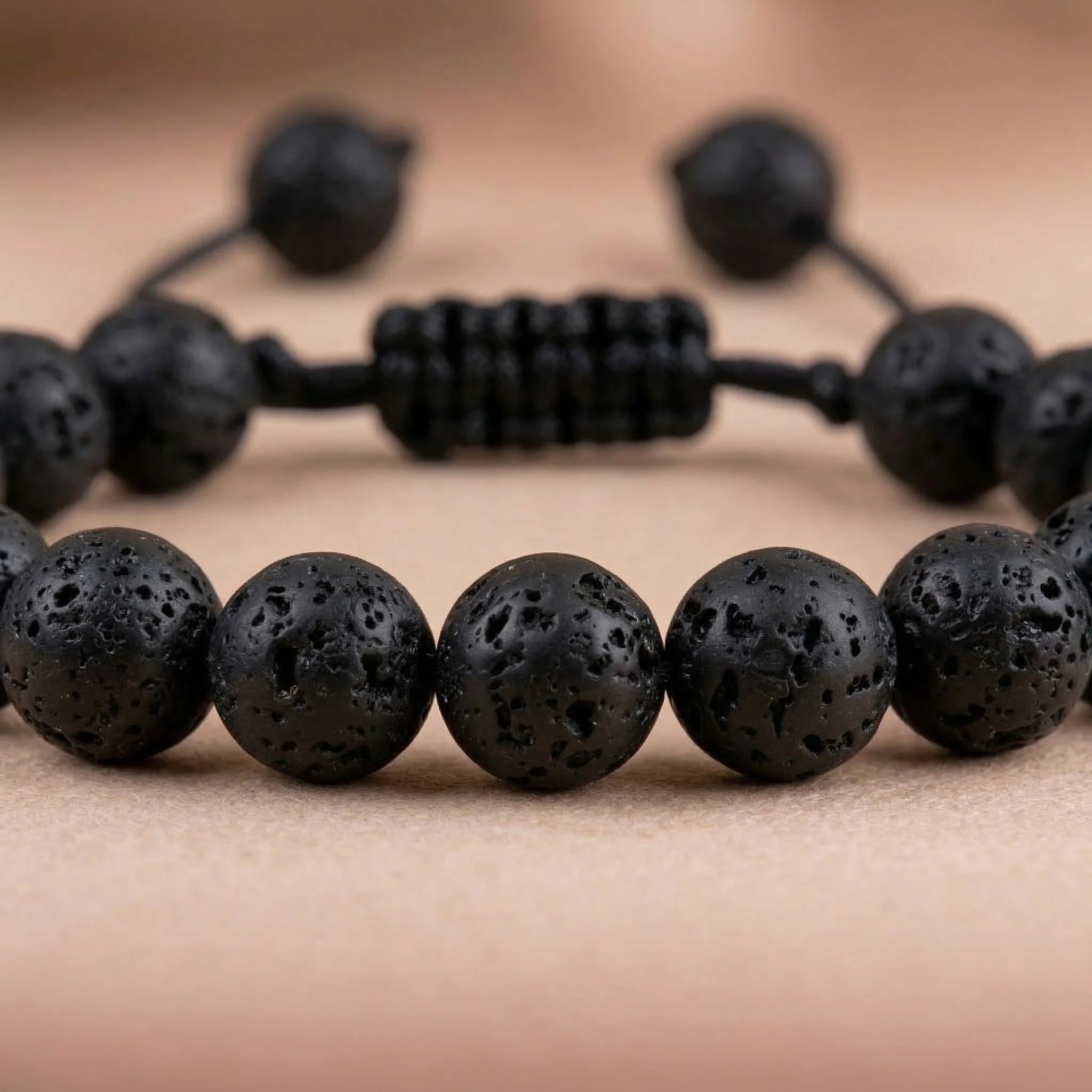 Black beaded bracelet on a beige background
