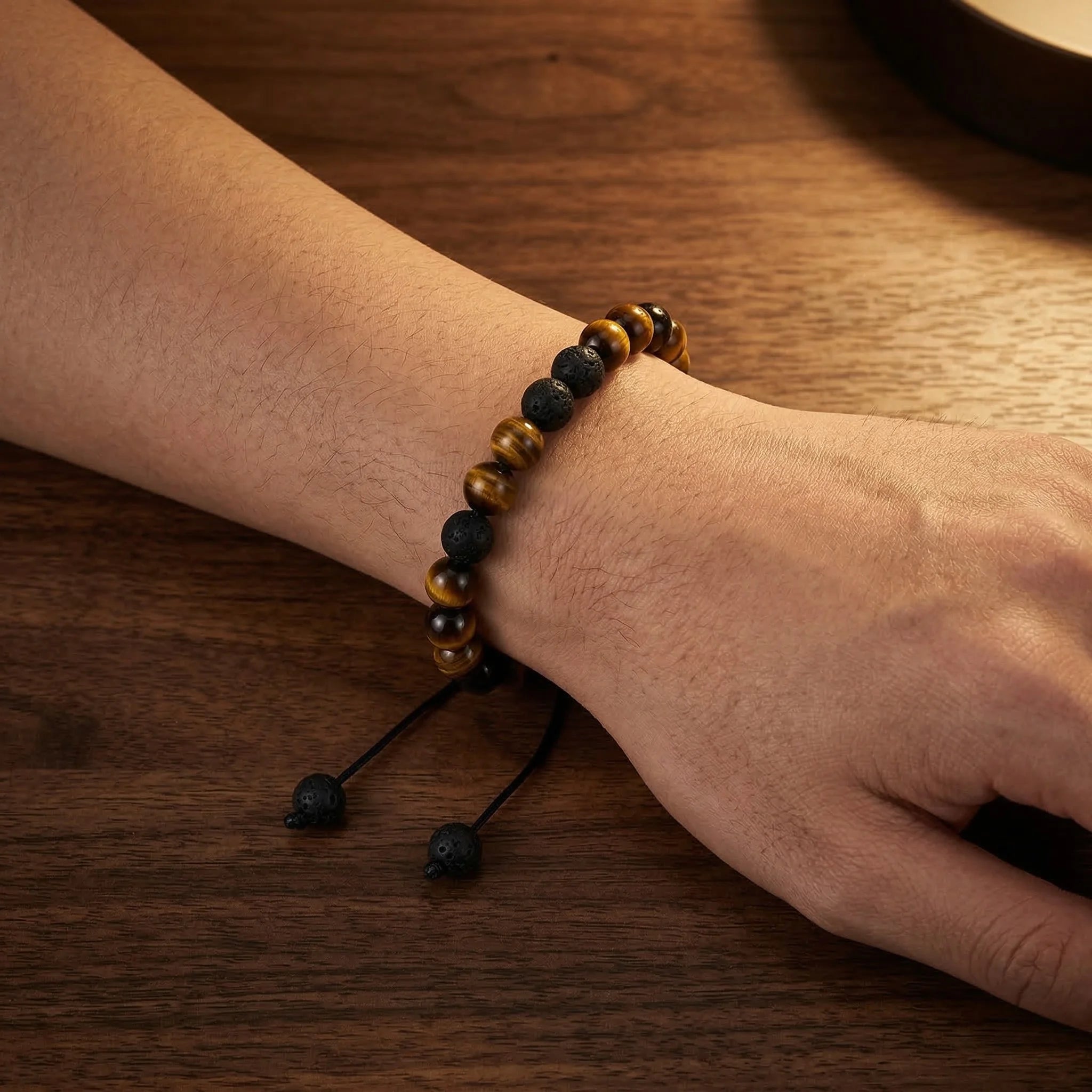 Close-up of a wrist wearing a beaded bracelet on a wooden surface