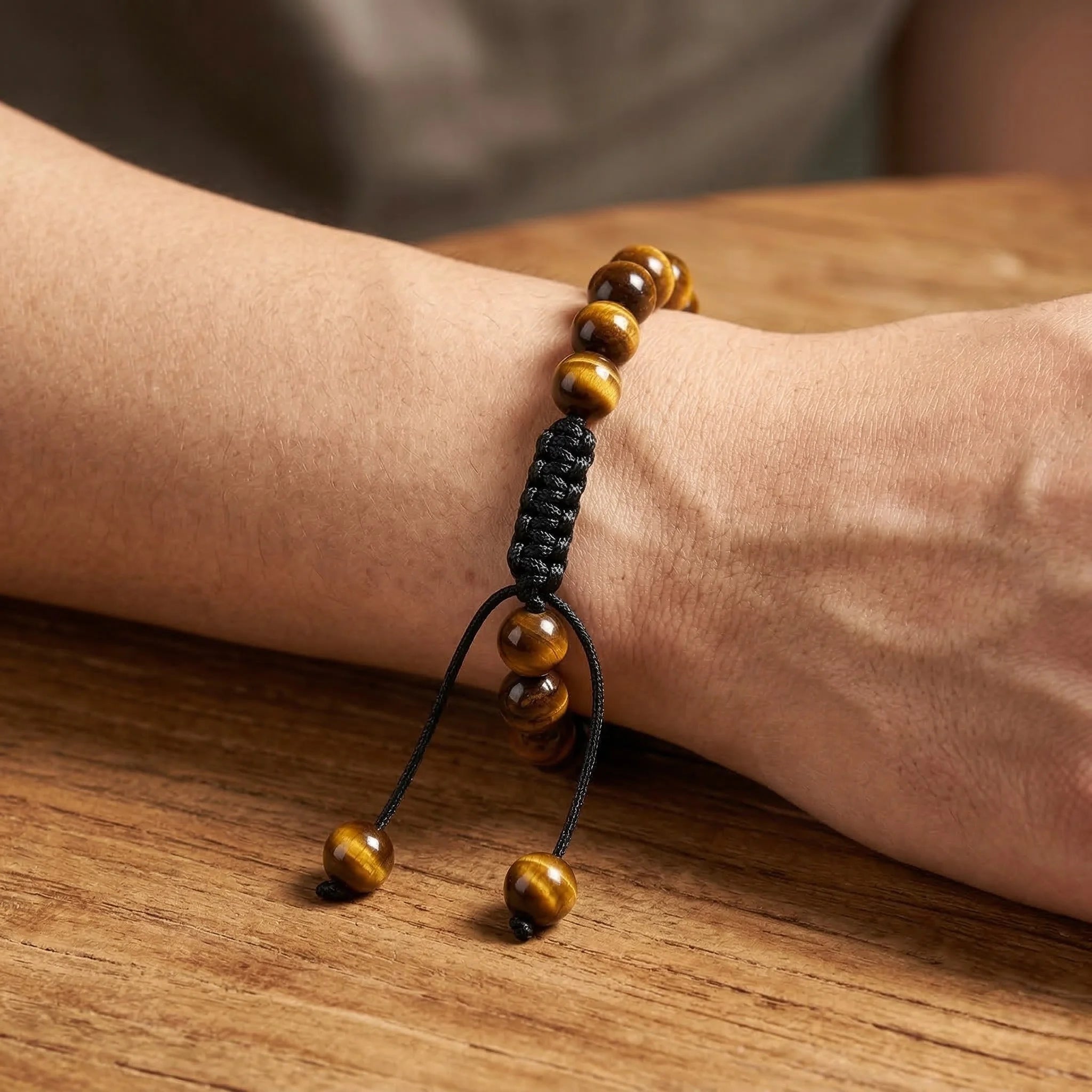 Bracelet with brown beads on a wrist against a wooden background