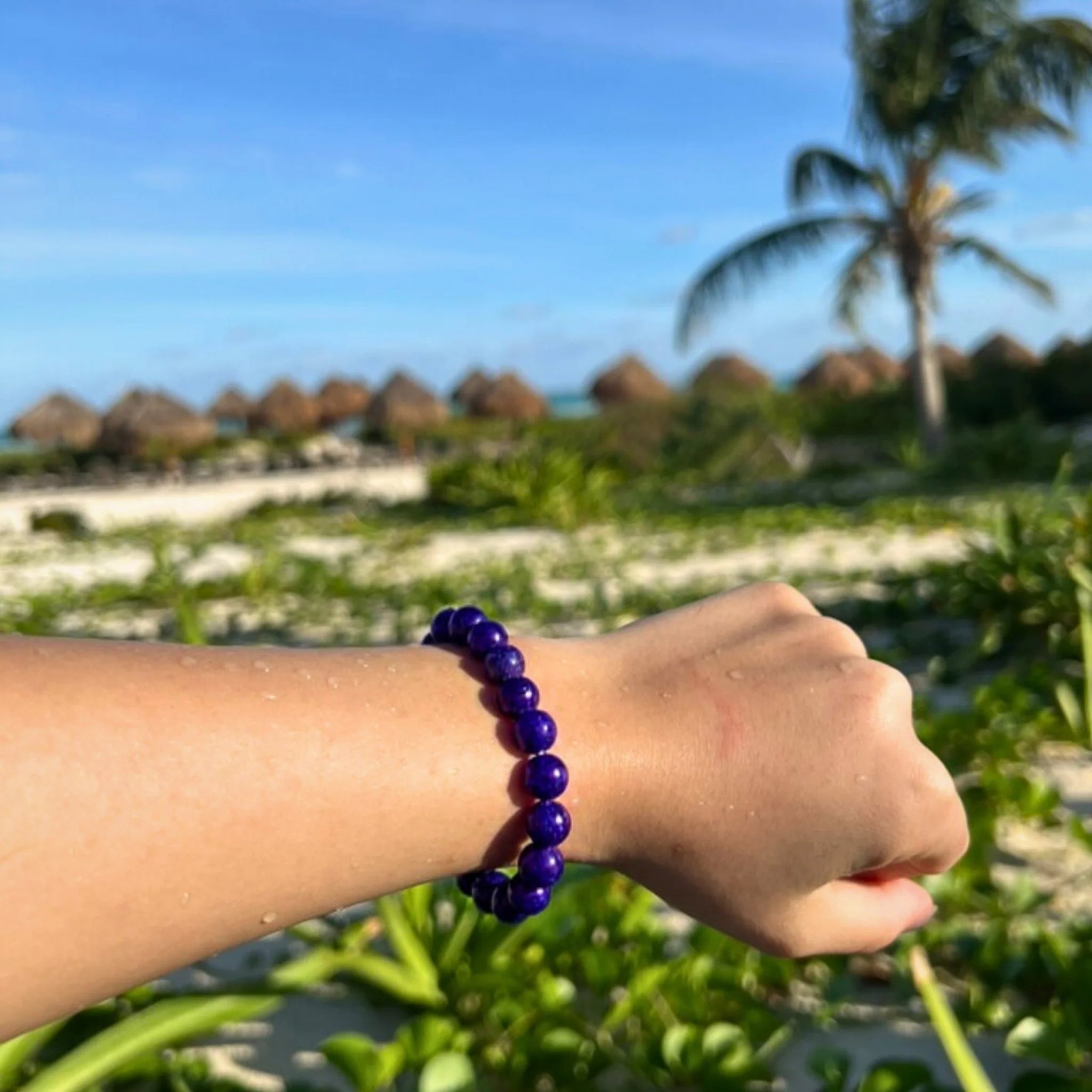 Gemstone4K amethyst bracelet worn on wrist outdoors, showing natural red earthy tone and polished beads.