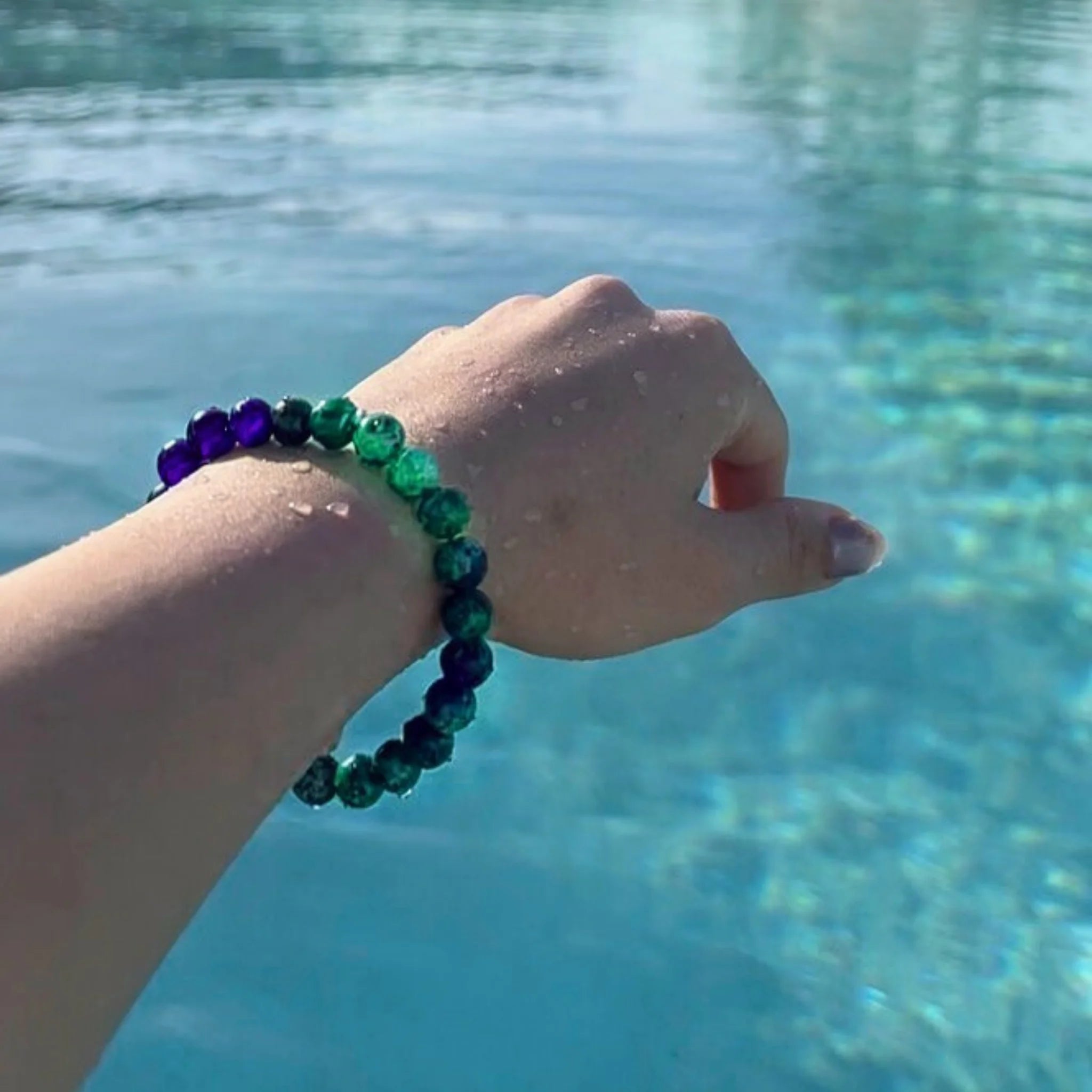 Gemstone4K fluorite bracelet worn on wrist outdoors, showing translucent lavender and green tones.