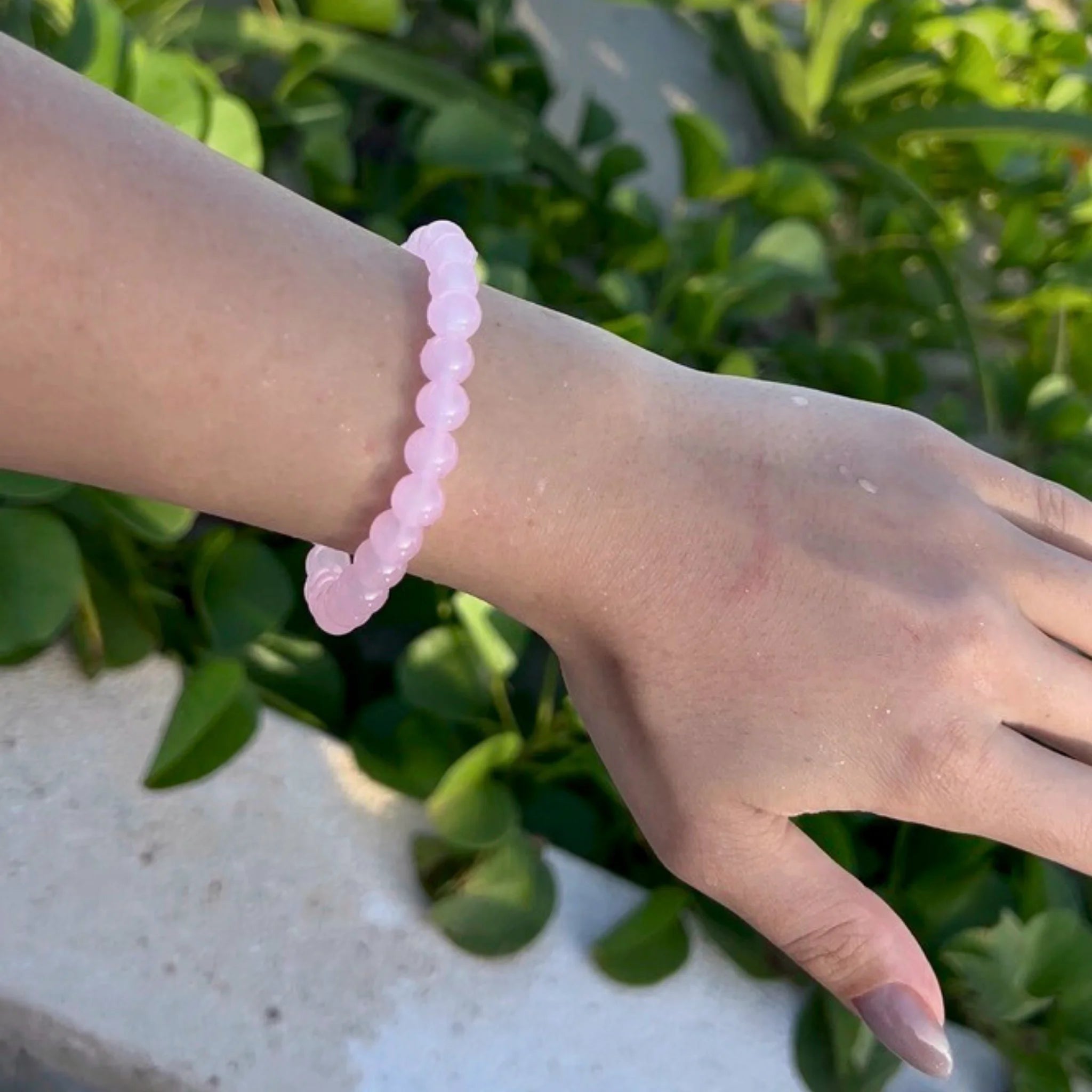 Gemstone4K rose quartz bracelet worn on wrist in soft natural light, highlighting pink calming tones.